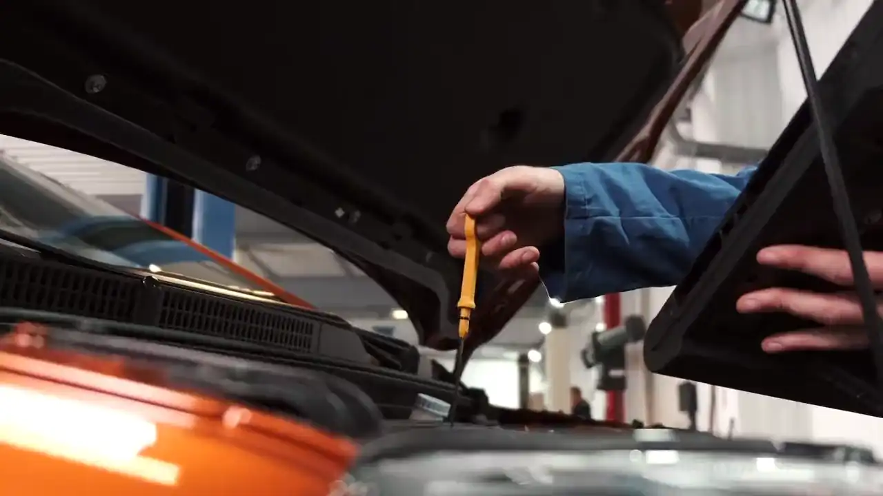 Ein Mechaniker prüft den Ölstand mit dem Messstab