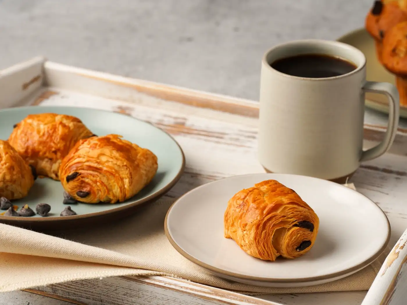 Croissants, Butter und Kaffee auf einem Frühstückstisch
